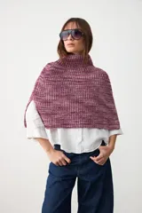 Capita tejida en punto acanalado, con cuello alto y diseño corto tipo poncho.