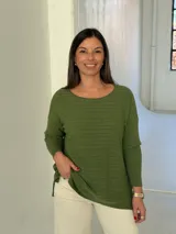 Sweater de punto color verde oliva con diseño de trenzas horizontales, cuello redondo y mangas largas con puños acanalados. Presenta un corte holgado con aberturas laterales en el ruedo.