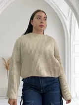 Sweater beige de punto grueso con cuello redondo y mangas largas.