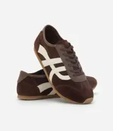 Championes estilo chutera marca Satinato, color marrón con detalles laterales en color crema. Presentan punta redondeada, cierre por cordones y suela plana de goma.