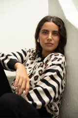 Saco de punto con diseño combinado de rayas horizontales en las mangas y estampado animal print en el cuerpo. Presenta cuello redondo, cierre frontal con botones y corte holgado.