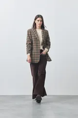 Pantalón de pana de corte wide leg, color marrón oscuro, con calce relajado y detalle de bordado en el borde de los bolsillos delanteros.
