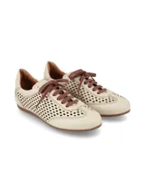 Championes de cuero graneado color crema, con diseño perforado en los laterales y empeine, cordones marrones y suela de goma al tono.