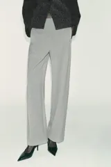 Pantalón recto color marrón oscuro, de tiro medio, con cintura elástica en la espalda, bolsillos delanteros de vivo y cierre frontal con cremallera, botón interior y gancho.