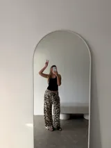 Pantalón negro de algodón y viscosa, con estampado de lunares blancos y corte holgado.