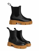 Botas tipo chelsea de cuero negro con textura granulada, paneles laterales elásticos y suela track de goma color suela con plataforma.