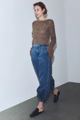 Pantalón de jean estilo bombacho con tiro medio, confeccionado en denim azul con costuras verticales decorativas y puños ajustados en el ruedo.