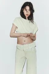 Camiseta cropped color verde menta, con cuello redondo y mangas cortas amplias con dobladillo.