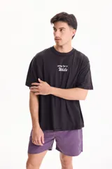 Remera negra de manga corta, confeccionada en algodón, con calce semi boxy y pequeño estampado frontal con la frase "away for a while".