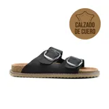 Sandalias bajas de cuero color beige con doble tira y hebillas metálicas doradas.