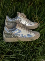 Championes blancos con detalles plateados con glitter y una estrella blanca en el lateral.