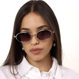Lentes de sol con armazón metálico plateado y forma ovalada. Cuentan con cristales oscuros con protección UV400.