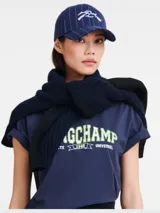 Gorro de béisbol azul con rayas verticales verdes y logo bordado en blanco.