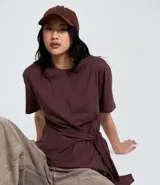Blusa de algodón color bordó, con cuello redondo, mangas cortas y diseño con lazo frontal tipo pañuelo.