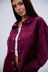 Sobrecamisa de gamuza en color violeta, con diseño de corte holgado, cuello camisero clásico, cierre frontal con botones metálicos a presión y dos bolsillos frontales tipo parche.