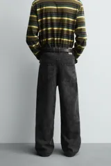 Pantalón de corte baggy fit confeccionado en tejido de algodón con textura y efecto lavado. Presenta diseño de cinco bolsillos, cierre frontal con cremallera y botón.