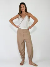 Pantalón color tostado de corte holgado, tiro alto con pinzas en la cintura y botamangas elastizadas.