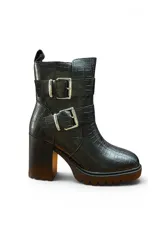 Bota de caña corta negra con textura efecto cocodrilo, suela track y taco ancho. Cuenta con dos tiras con hebillas metálicas plateadas en el lateral de la caña.