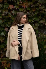 Chaquetón cruzado de estilo peluche, con solapas amplias, bolsillos laterales y corte oversized.