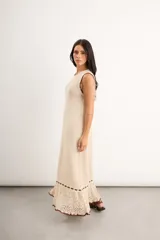Vestido largo de punto color bordó con diseño sin mangas, cuello redondo y detalles de ribete en color celeste en el cuello, sisas, ruedo y a lo largo de la parte inferior, culminando en un acabado calado con volados.