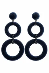 Caravanas colgantes de diseño largo y geométrico, tapizadas en terciopelo azul. Cuentan con un botón superior esférico y dos aros concéntricos unidos por eslabones metálicos oscuros.