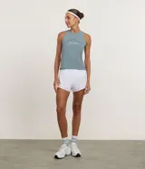 Musculosa deportiva femenina color azul verdoso, con cuello redondo y sisas amplias. Presenta un estampado frontal con el texto curvo "ATHLETIC CLUB est. 1990".