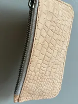 Billetera tarjetero de cuero con cierre y espacio para billetes y monedas.