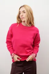 Buzo de punto color fucsia, con cuello redondo y mangas largas.