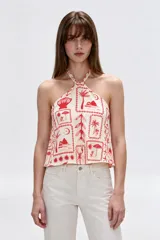 Top de viscosa con escote halter, tirantes finos, diseño holgado y estampado de motivos veraniegos en tonos rojos sobre base beige.
