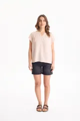 Blusa negra de manga corta, confeccionada en tela crepé, con detalle de fruncido en el escote redondo y pequeña abertura frontal en V.