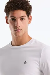 Remera de manga larga color blanco, con cuello redondo y un pequeño logo bordado de pingüino en el pecho.