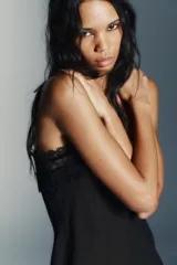 Top de tirantes finos confeccionado en tejido semitransparente, con escote recto decorado con encaje a tono, bordados florales y detalles de terciopelo con lazos. Presenta un diseño con abertura frontal y bajo con encaje.