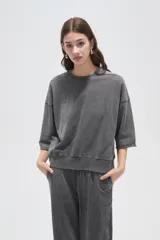 Buzo de algodón con efecto lavado, cuello redondo, mangas 3/4 y corte holgado.