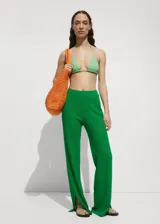 Pantalon de crochet color verde, de corte recto y largo, con cintura elástica y aberturas laterales en el bajo.