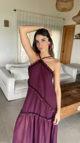 Vestido largo color bordó con escote halter y detalles de volados diagonales.