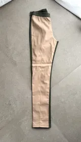 Pantalón de cuero sintético beige con paneles laterales y pretina elástica en color verde militar.