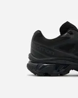 Championes Salomon modelo XT-6, color negro, diseñados para trail running con tecnología de amortiguación y suela de alta tracción. Presentan un sistema de cordones de ajuste rápido y refuerzos en la puntera.