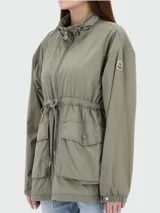 Parka color verde militar, con cuello alto, cierre frontal con cremallera, cintura ajustable con cordón, cuatro bolsillos frontales con solapa y puños elásticos.