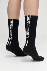 Pack de dos pares de medias blancas de caña alta, con base de toalla y logo de la marca en negro.