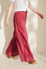 Pantalón de lino blanco de corte wide leg, con diseño amplio y costuras pespunteadas a contratono.