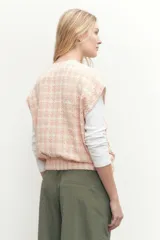 Chaleco de tweed color salmón con diseño a cuadros, sin mangas, con bolsillos frontales y botones perlados.
