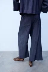 Pantalón de tiro medio color azul, corte ancho y fluido, con cintura elástica fruncida y cordón ajustable.