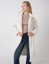 Tapado largo color blanco de tejido bouclé, marca Bcbg Maxazria. Cuenta con cuello de solapa amplia, cierre frontal con botones a presión internos, bolsillos funcionales y tajos laterales en el bajo. Forro interno a tono.