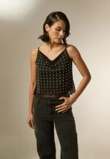 Musculosa negra de poliéster con cuello buche, breteles finos y apliques de tachas metálicas en toda la parte frontal.