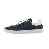 Championes Lacoste modelo Baseshot, de diseño urbano y perfil bajo. Confeccionados en gamuza color azul marino, presentan cordones blancos, suela de goma blanca y el logo del cocodrilo bordado en el lateral con la inscripción EST. 1933.