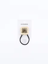 Colero de pelo con adorno cuadrado dorado con textura.