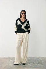 Sweater de tejido bouclé con diseño de animal print abstracto en blanco y negro, cuello en V y corte holgado.