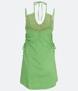 Vestido corto verde de lino con tirantes finos ajustables, escote halter con lazo y cutouts laterales con lazos.
