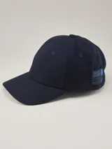 Gorra de béisbol de paño en color azul marino, con etiqueta lateral con logo de la marca.