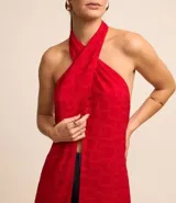 Túnica larga roja con textura jacquard de formas geométricas cuadradas, cuello halter con lazo para anudar y espalda descubierta.